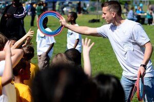 U.S. Air Force Senior Airman Kody Conley, 94th Air Maintenance Unit F-22 Raptor crew chief, passes Frisbee discs out to participants of the Special Games at Oscar Smith High School in Chesapeake, Va., April 26, 2013. Conley was part of the more than 100 Airmen from Langley Air Force Base that volunteered to assist the Special Games.  (U.S. Air Force photo by Senior Airman Kayla Newman/Released)