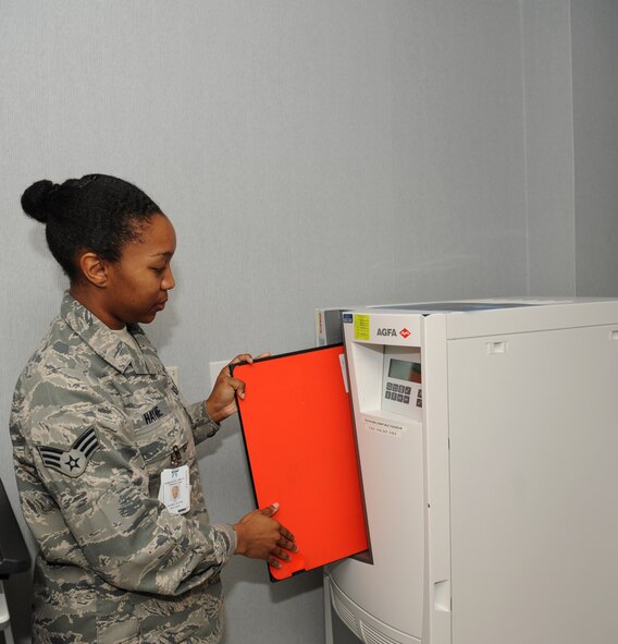 Senior Airman Natisha Haynie, 2nd Medical Support Squadron diagnostic imaging technologist, inserts film into a digital film processor at the radiology lab on Barksdale Air Force Base, La., May 3, 2013. The machine processes the film digitally and sends it to a computer for a doctor to review it. (U.S. Air Force photo/Airman 1st Class Benjamin Gonsier)