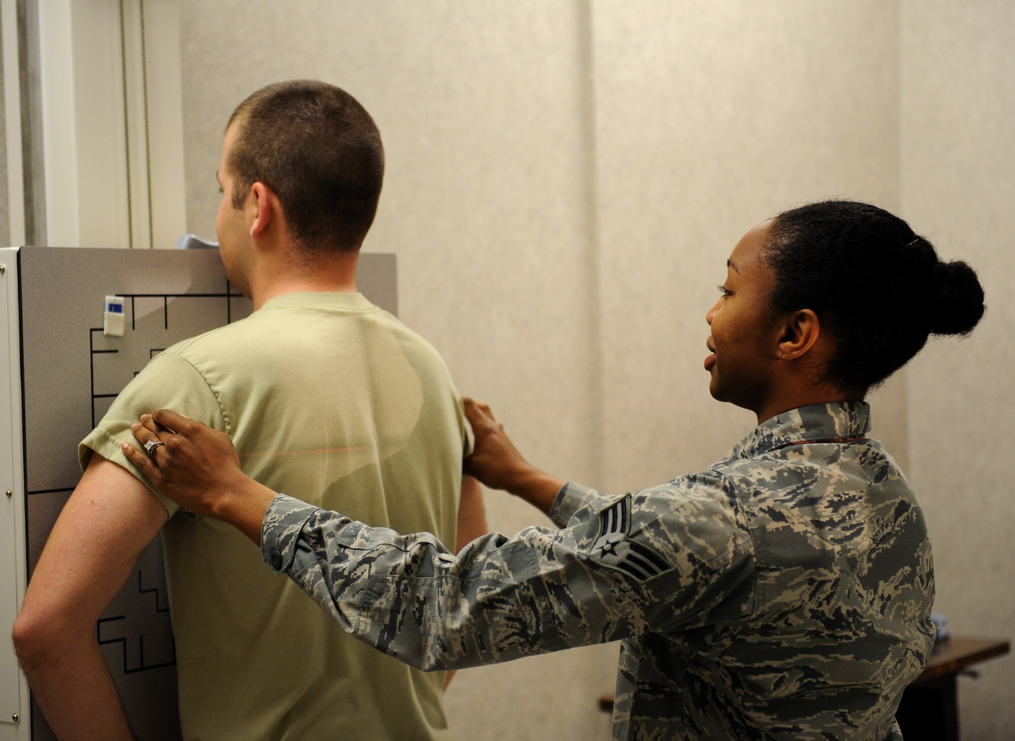 Senior Airman Natisha Haynie, 2nd Medical Support Squadron diagnostic imaging technologist, sets up an Airman for an X-ray at the radiology lab on Barksdale Air Force Base, La., May 3, 2013. The X-ray machine emits X-radiation to capture an image of the internal structures of the human body to provide doctors a way to see inside the body to locate possible injuries. (U.S. Air Force photo/Airman 1st Class Benjamin Gonsier)
