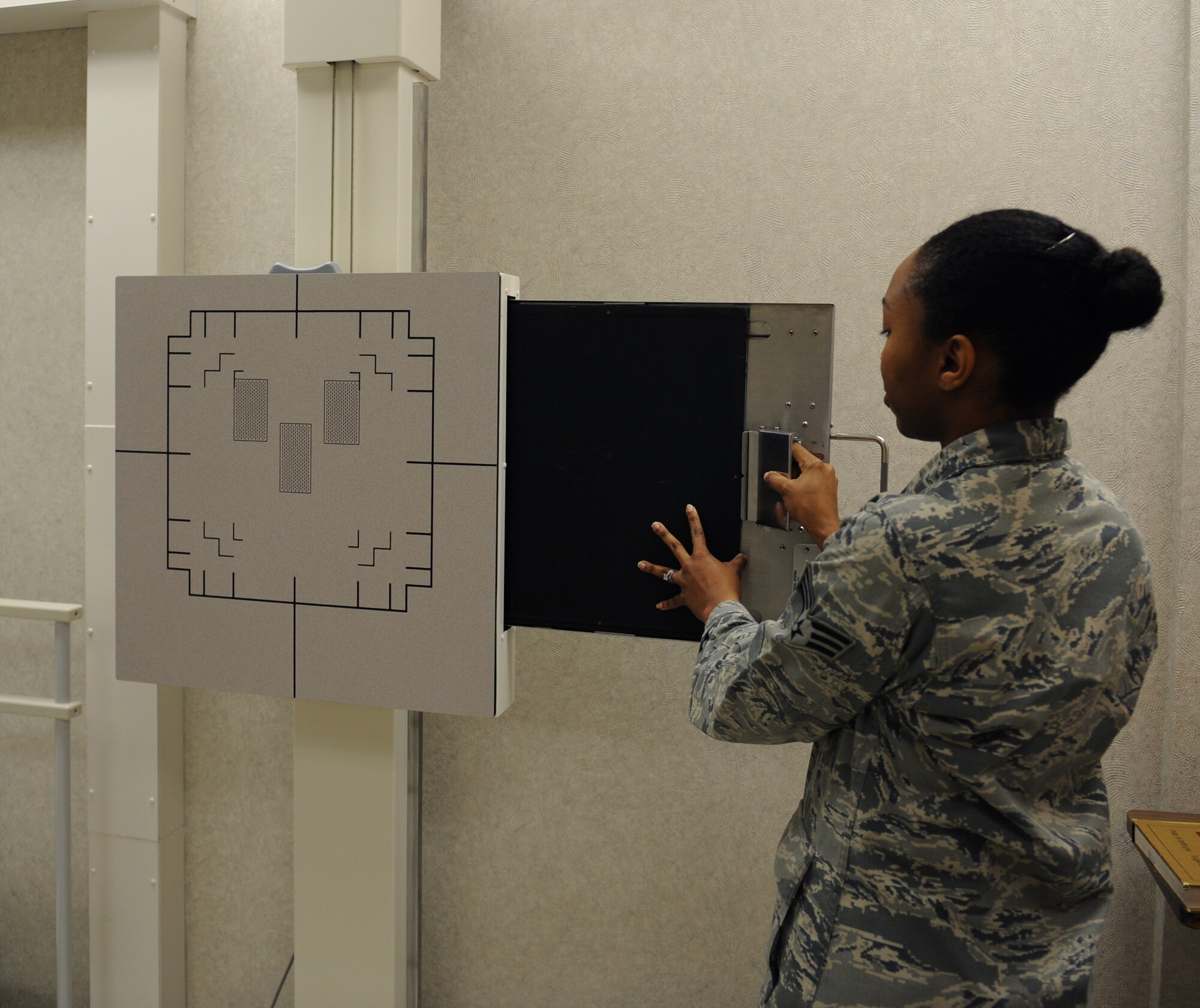 Senior Airman Natisha Haynie, 2nd Medical Support Squadron diagnostic imaging technologist, inserts film into an X-ray machine at the radiology lab on Barksdale Air Force Base, La., May 3, 2013. Radiology technicians specialize in machines that see the deepest parts of the body and provide medical imaging to doctors. (U.S. Air Force photo/Airman 1st Class Benjamin Gonsier)
