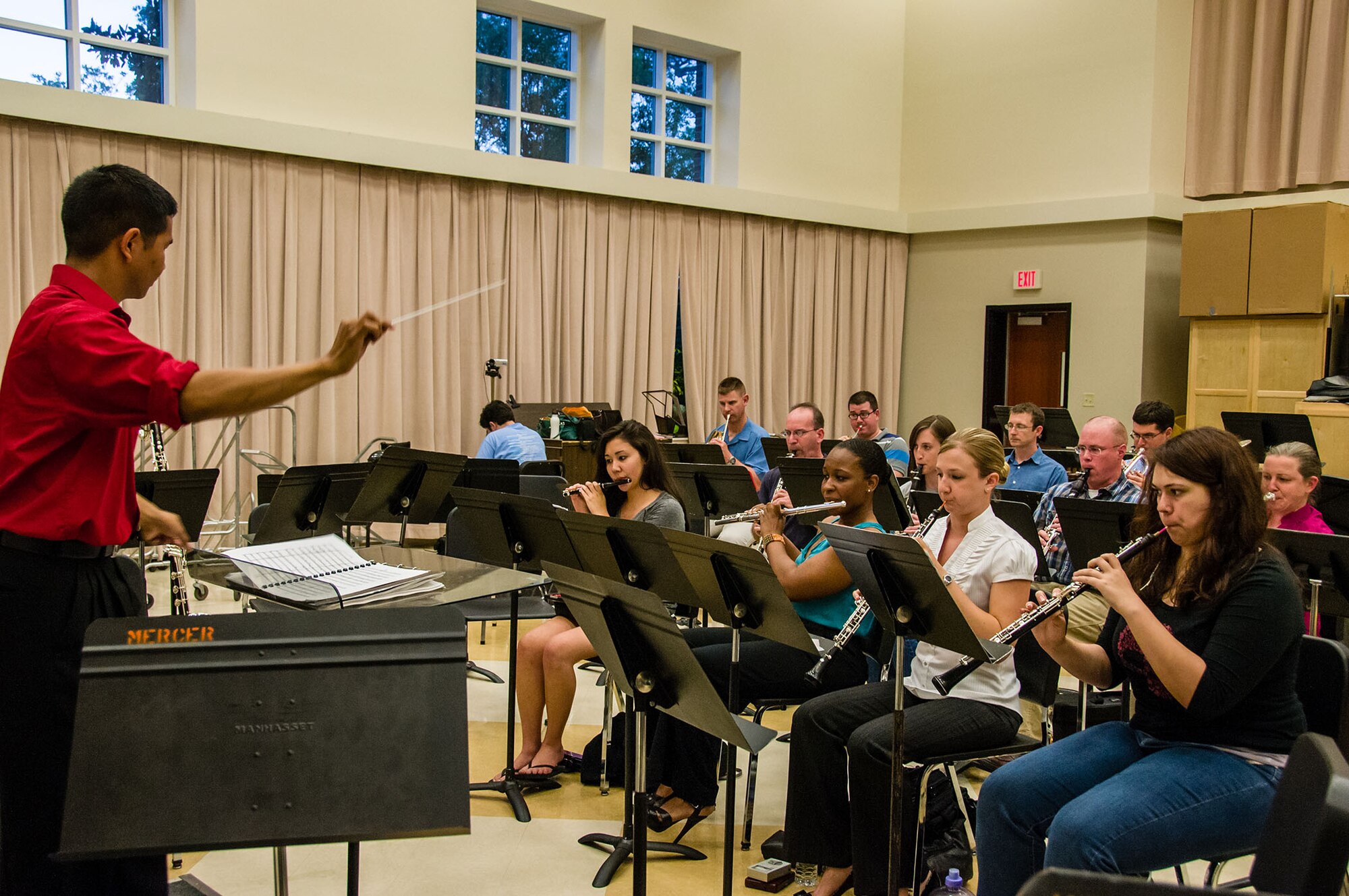 First Lt. Thomas Gamboa, commander of the Band of the U.S. Air Force Reserve, conducts a musical piece during a Macon Symphony Youth Orchestra rehearsal. The organizations prepare for their performance together for the Kaleidoscope Concert May 4, 2013. This is the second time the groups have performed together and will be the last public performance for the Reserve Band before their unit inactivates Sept. 30, 2013. (U.S. Air Force photo/Staff Sgt. Alexy Saltekoff)