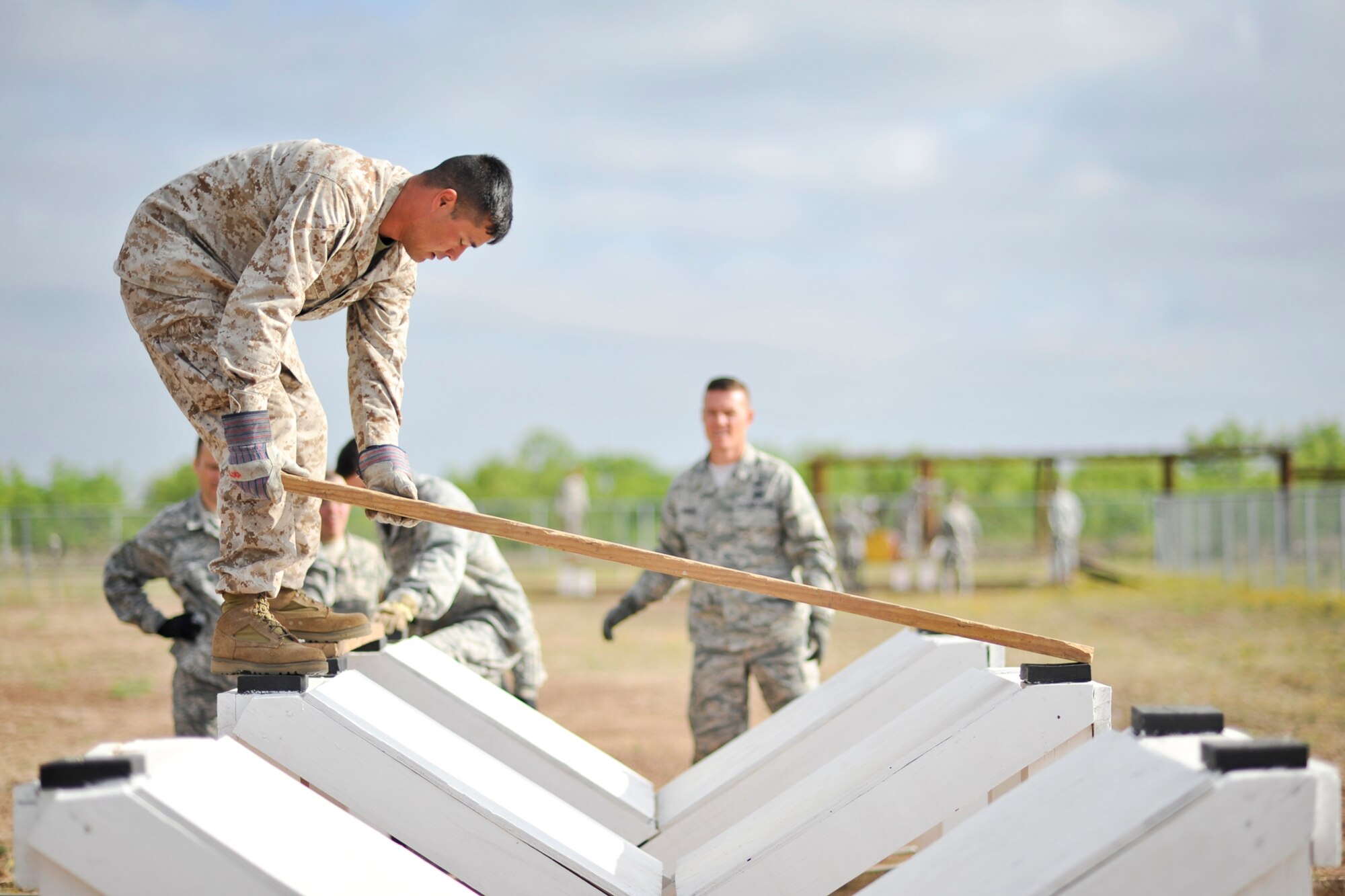GOODFELLOW AIR FORCE BASE, Texas-- Marine Master Sgt. Nicholas Franchuk, Marine Corps Detachment liaison officer, places down a wooden plank during the Leadership Reaction Course April 30. Each obstacle tests the participant’s strength, determination, communication and problem solving skills. (U.S. Air Force photo/ Airman 1st Class Michael Smith)