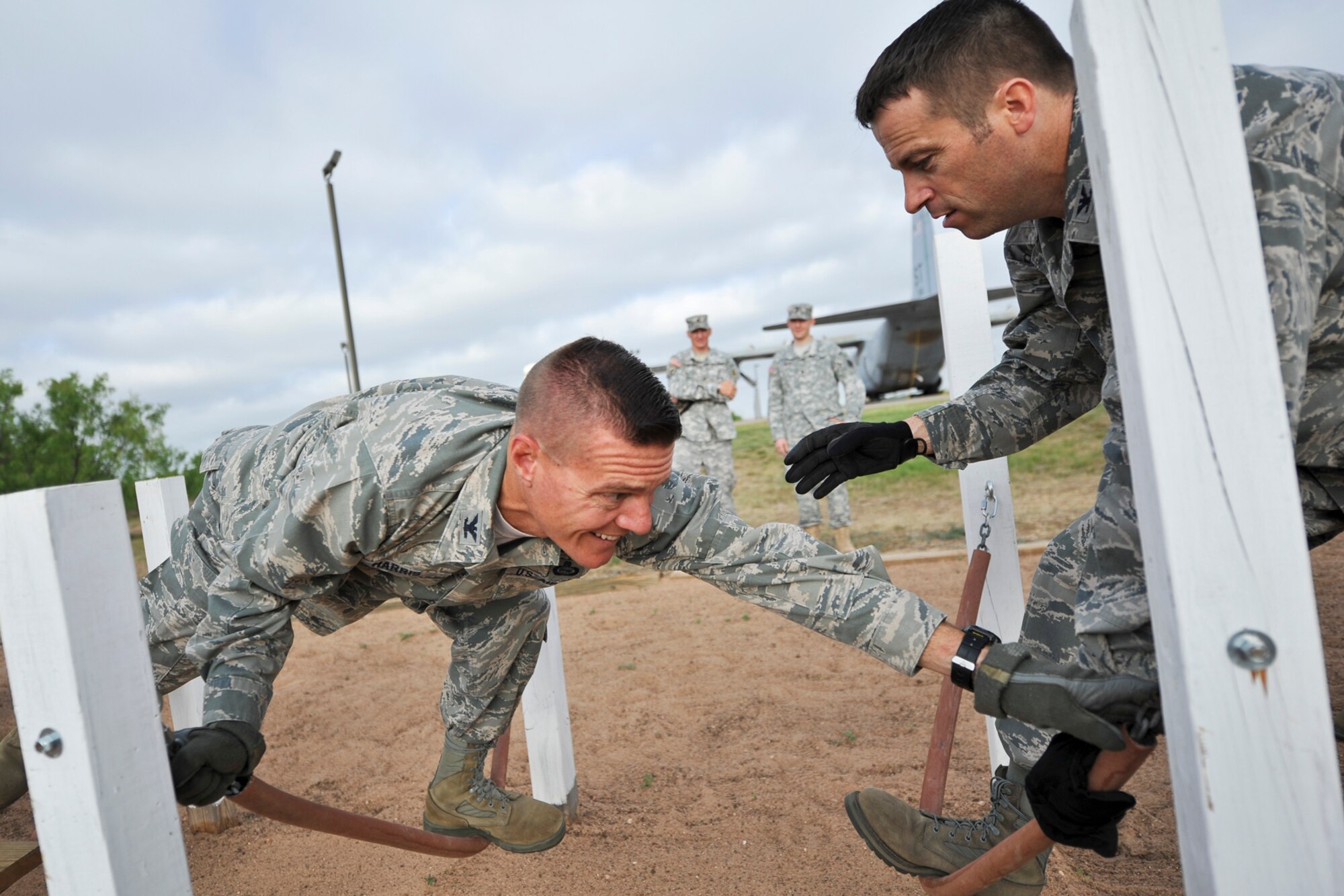 GOODFELLOW AIR FORCE BASE, Texas-- Col. Brendan Harris, 17th Training Group Commander, reaches for a chain while Col. Thomas Schmidt, 17th Training Wing Vice Commander, assists during the Leadership Reaction Course April, 30. Each obstacle tests the participant’s strength, determination, communication and problem solving skills. (U.S. Air Force photo/ Airman 1st Class Michael Smith)