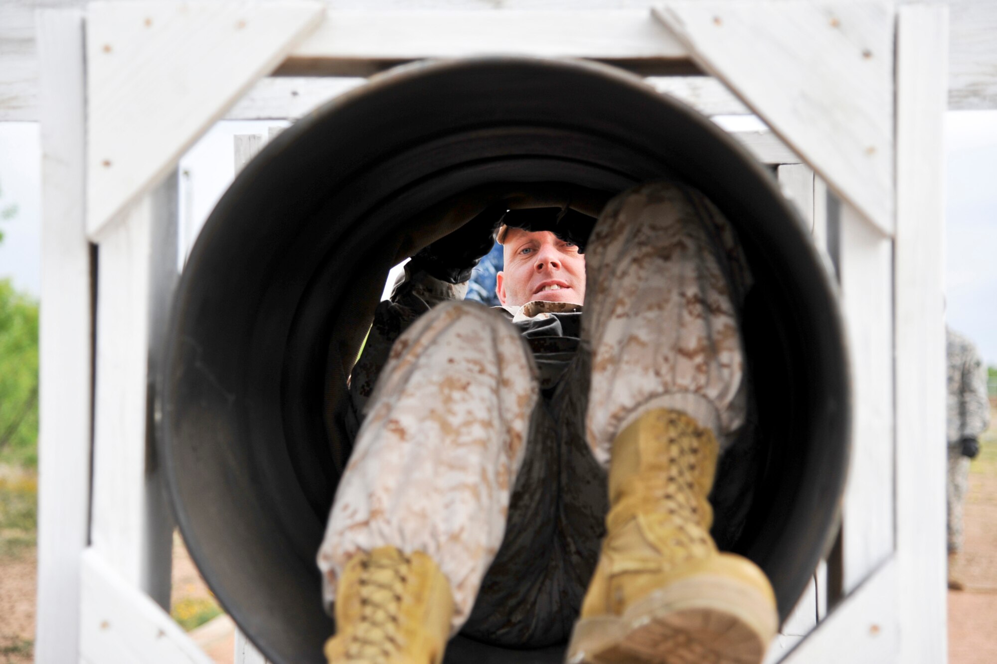 GOODFELLOW AIR FORCE BASE, Texas-- Marine Maj. Douglas March, Marine Corps Detachment Commander, climbs through a tube while participating in the Leadership Reaction Course April 30. The course is designed to help individuals discover leadership qualities and develop teamwork by completing obstacles. (U.S. Air Force photo/ Airman 1st Class Michael Smith)