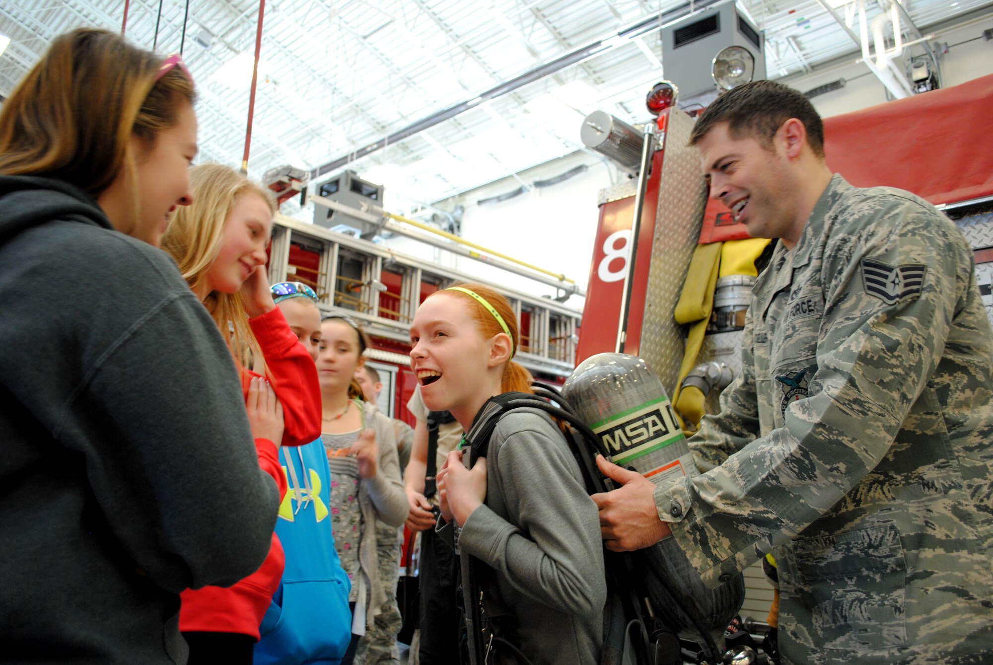 Staff Sgt. Jack Toeller, 319th Civil Engineer Squadron, allows 5th- and 6th-grade students from St. Joseph’s Catholic School in Devils Lake, N.D., to find out how heavy a fireman’s oxygen tank really is during a base tour on April 26, 2013. Grand Forks Air Force Base offers base tours each Friday from March through October.  (U.S. Air Force photo/Staff Sgt. Luis Loza Gutierrez)