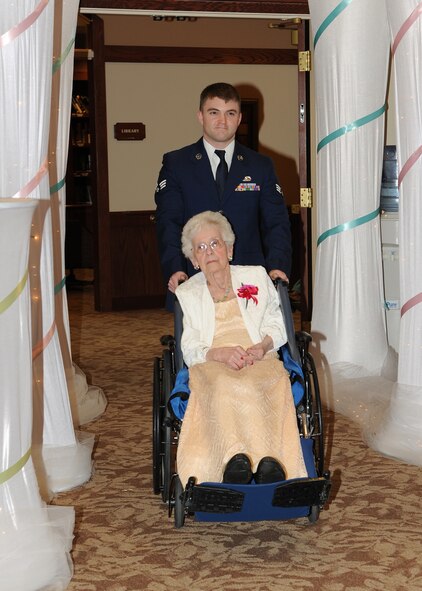 Senior Airman Joshua Dickens, 319th Logistics Readiness Squadron, escorts Lorraine Porter into the ballroom during the Annual Senior Prom Grand March at Woodside Village Valley Memorial Home, April 26, 2013, in Grand Forks, N.D. This year, eight Airmen escorted 75 residents to their senior prom.  (U.S. Air Force photo/Airman 1st Class Ashley Nicole Taylor)