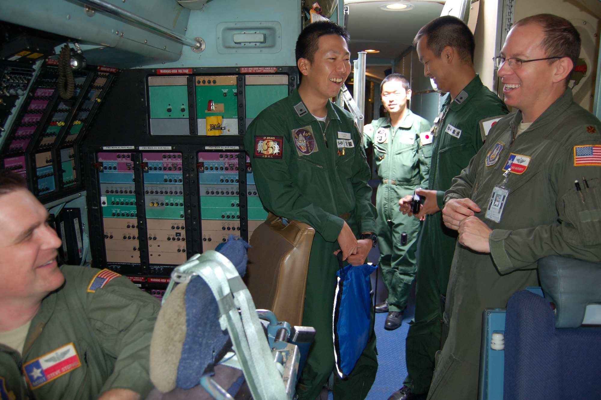 C-5A Galaxy loadmaster Master Sgt. Steve Stophel, left, and C-5A pilot Maj. Chris Garnett--both assigned to the 356th Airlift Squadron; share flying anecdotes with visiting pilots from the Defense Language Institute-English Language Center.  Visitors were among 14 other pilots who visited the "Alamo Wing" May 2 to learn about the giant aircraft and to show off their newly-acquired aviation English skills by talking with the 356 AS aircrew.  (U.S. Air Force photo by Elsa Martinez)