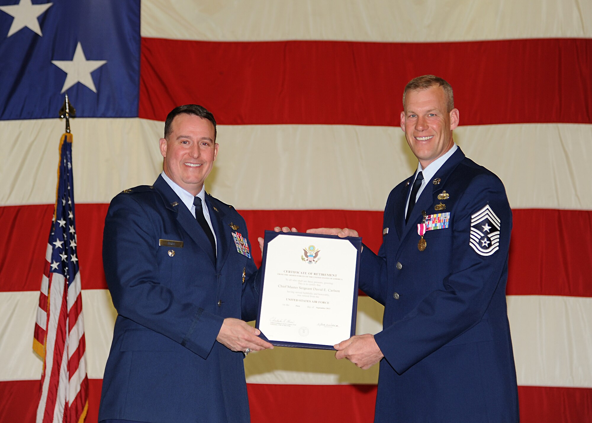 Former 319th Air Base Wing Commander Col. Tim Bush, left, presents Command Chief Master Sergeant David Carlson a Certificate of Retirement during Carlson’s retirement ceremony May 2, 2013, at Grand Forks Air Force Base, N.D. (U.S. Air Force photo/A1C Xavier Navarro)