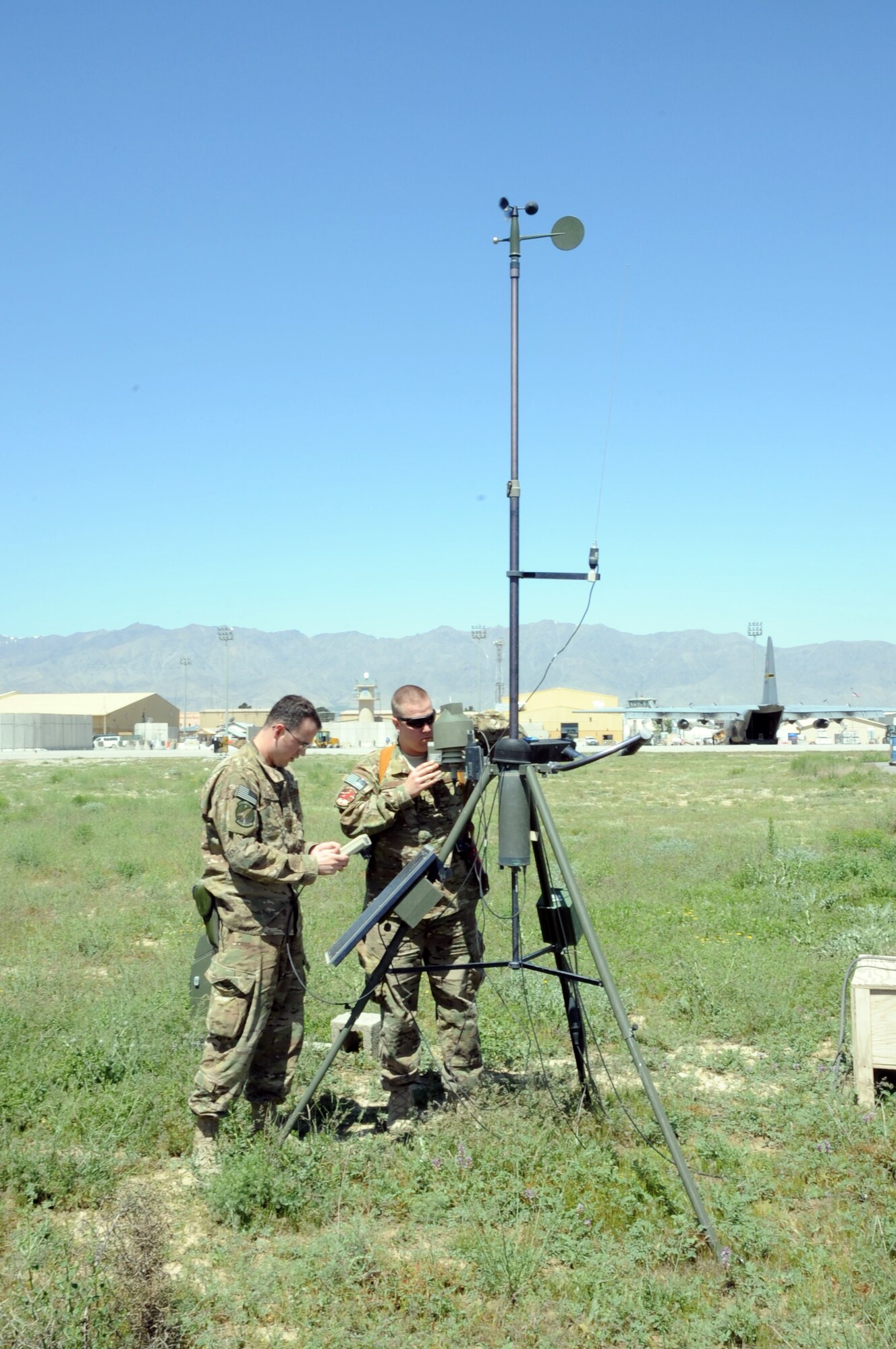 Senior Airman Jonathan Twyman, 455th Expeditionary Operations Support Squadron weather forecaster (left), and Capt. Thaddeus Fridgen, 455th EOSS weather flight commander, troubleshoot a tactical weather station on the flightline on Bagram Airfield, Afghanistan, May 1, 2013. Stations such as this one are set up in multiple locations to gather data on temperature, rainfall, etc., to aid in creating forecasts. (U.S. Air Force photo/Staff Sgt. David Dobrydney)