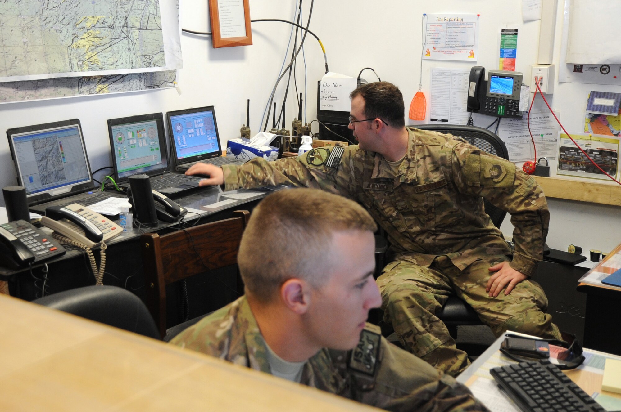 Senior Airmen Zachary Sura and Jonathan Twyman, 455th Expeditionary Operations Support Squadron weather forecasters, monitor weather patterns in the 455th EOSS weather flight office on Bagram Airfield, Afghanistan, May 1, 2013. The flight is responsible for providing the busiest single runway in the Department of Defense with accurate and timely weather information. (U.S. Air Force photo/Staff Sgt. David Dobrydney)