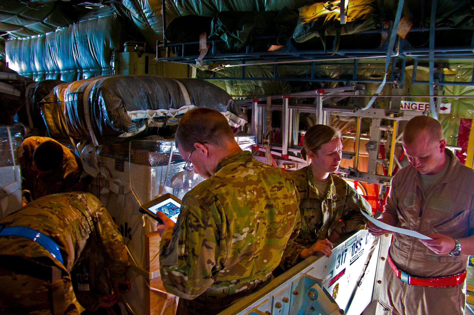 Crewmembers make final preparations before launching the first Extracted Container Delivery System airdrop mission in combat, April 29. The mission highlighted the benefits of XCDS, which uses a parachute to pull the bundles out of the aircraft faster while also creating smaller dispersion, resulting in a more accurate airdrop and easier pickup for Soldiers on the ground. (U.S. Air Force photo by Senior Airman Scott Saldukas) 