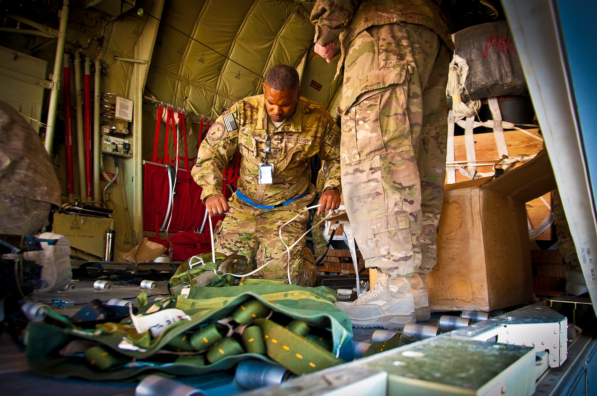 Master Sgt. DeMond Connors, 772nd Expeditionary Airlift Squadron superintendent, secures a load in a C-130J Hercules before an airdrop mission, April 29. The airdrop mission was the first use of Extracted Container Delivery System in Afghanistan, a new, more accurate, method of airdrop, resulting in about a two-thirds smaller dispersion of the bundles on the drop zone. Connors is deployed from Little Rock Air Force Base, Ark. (U.S. Air Force photo by Senior Airman Scott Saldukas)