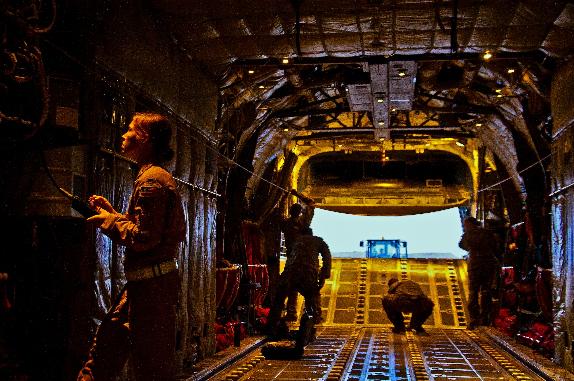 Airmen prepare a C-130J Hercules for an airdrop mission April 29. The airdrop mission was the first use of Extracted Container Delivery System in Afghanistan, a new, more accurate, method of airdrop designed to pull the bundles out of the aircraft faster than a normal airdrop, while resulting in a smaller dispersion of bundles in the drop zone. (U.S. Air Force photo by Senior Airman Scott Saldukas)