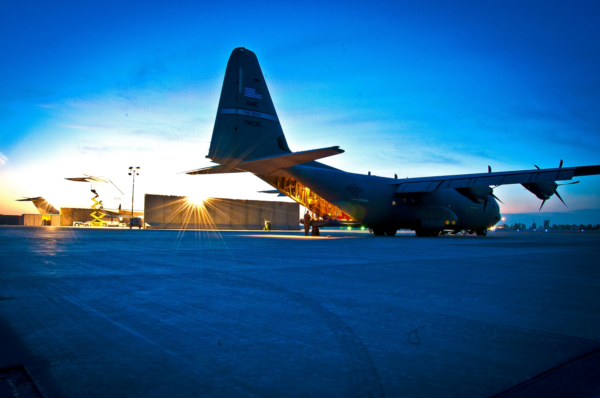 A C-130J Hercules sits on the flightline at Kandahar Airfield, as crews work to prepare the aircraft for an airdrop mission April 29. The airdrop mission was the first use of Extracted Container Delivery System in Afghanistan, a new, more accurate, method of airdrop designed to pull the bundles out of the aircraft faster. (U.S. Air Force photo by Senior Airman Scott Saldukas)