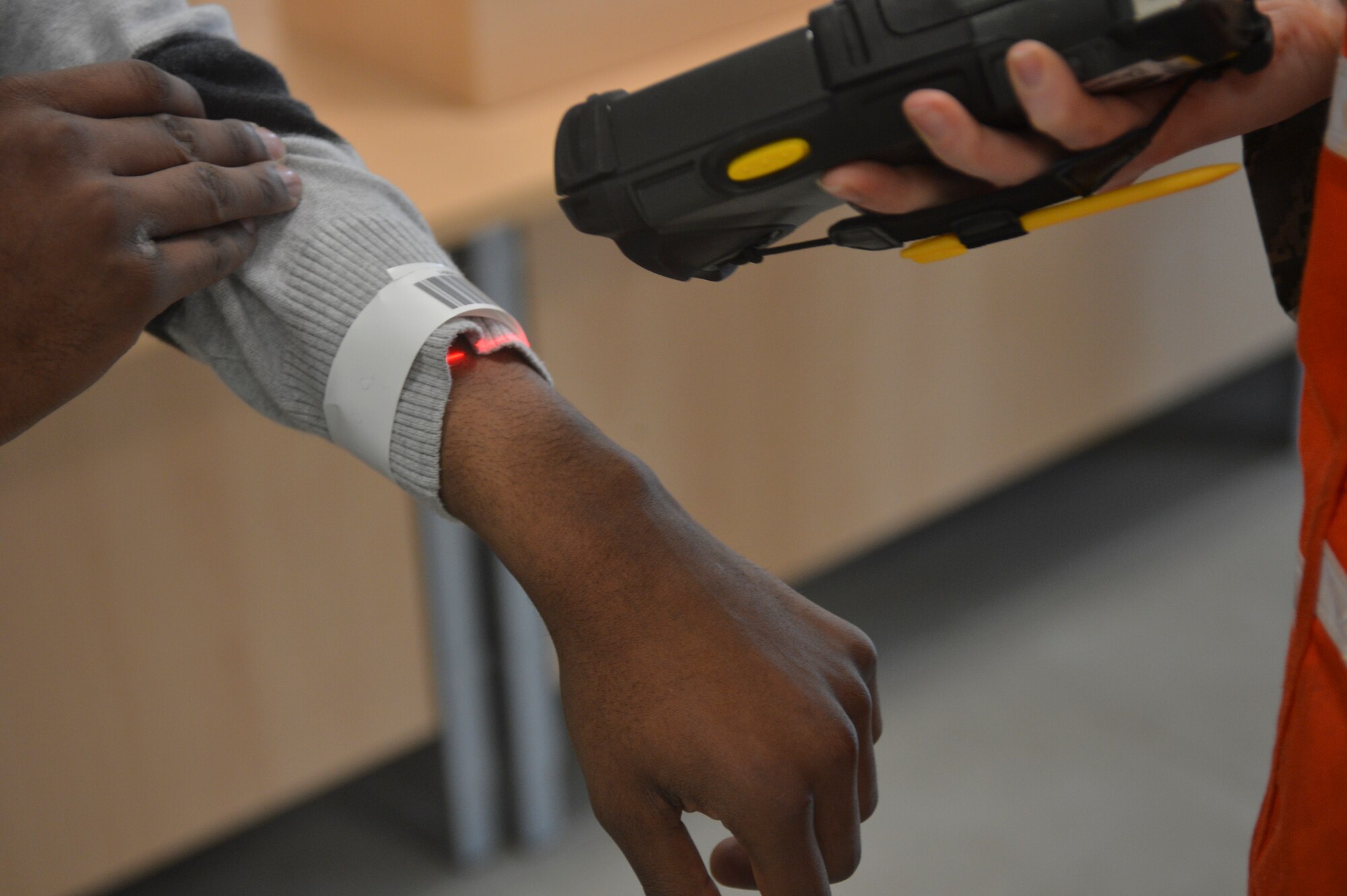An “evacuee” has his identification band scanned and registered during a readiness inspection on Ramstein Air Base, Germany, May 2, 2013. The purpose of this readiness inspection was to test Ramstein’s Airmen ability to safely evacuate and receive noncombatants from a hostile environment.  (U.S. Air Force photo/Airman 1st Class Jordan Castelan)