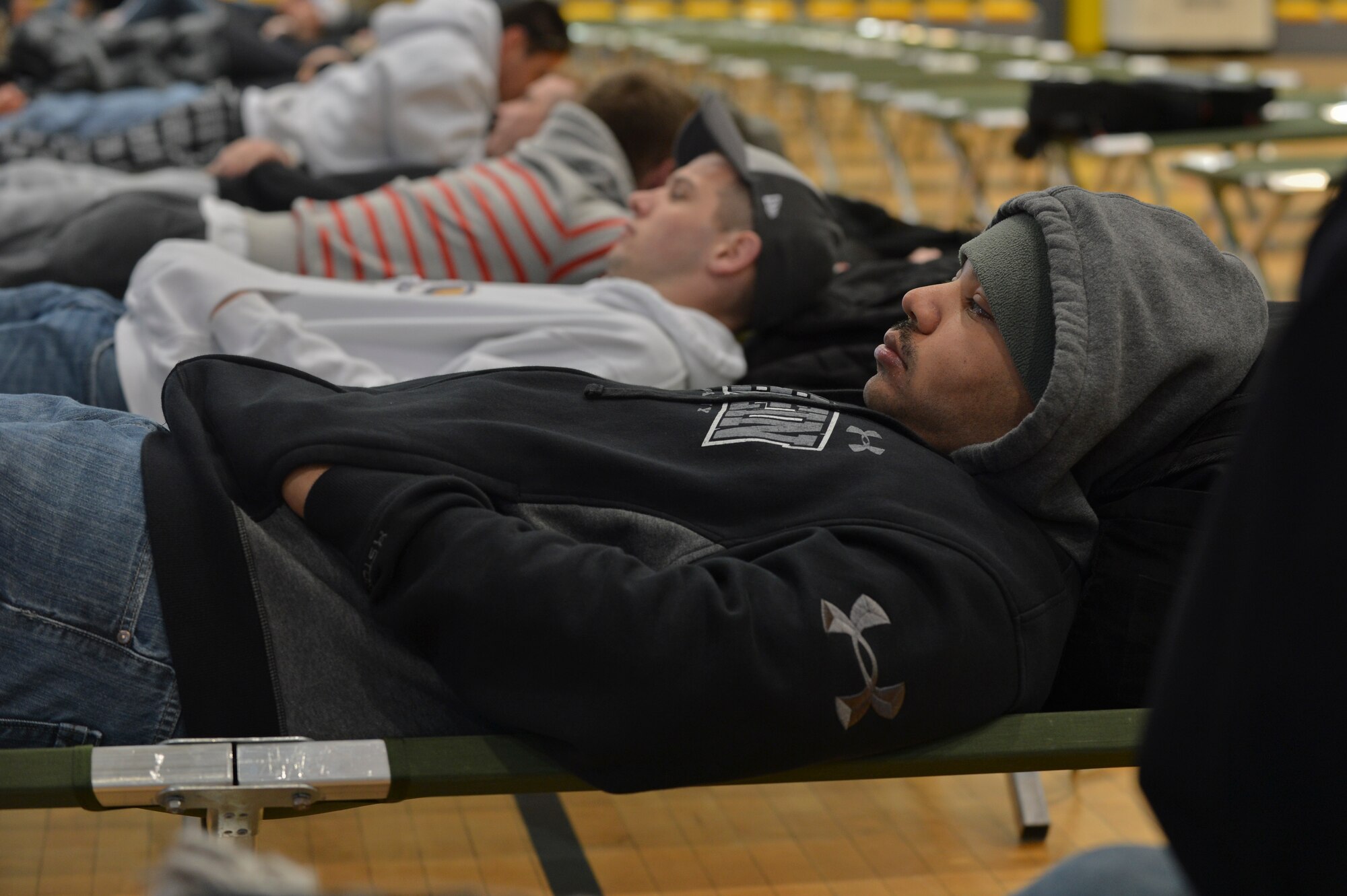“Evacuees” rest while awaiting transportation during a readiness inspection on Ramstein Air Base, Germany, May 3, 2013. The purpose of this readiness inspection was to test Ramstein’s Airmen ability to safely evacuate and receive noncombatants from a hostile environment. (U.S. Air Force photo/Airman 1st Class Jordan Castelan)