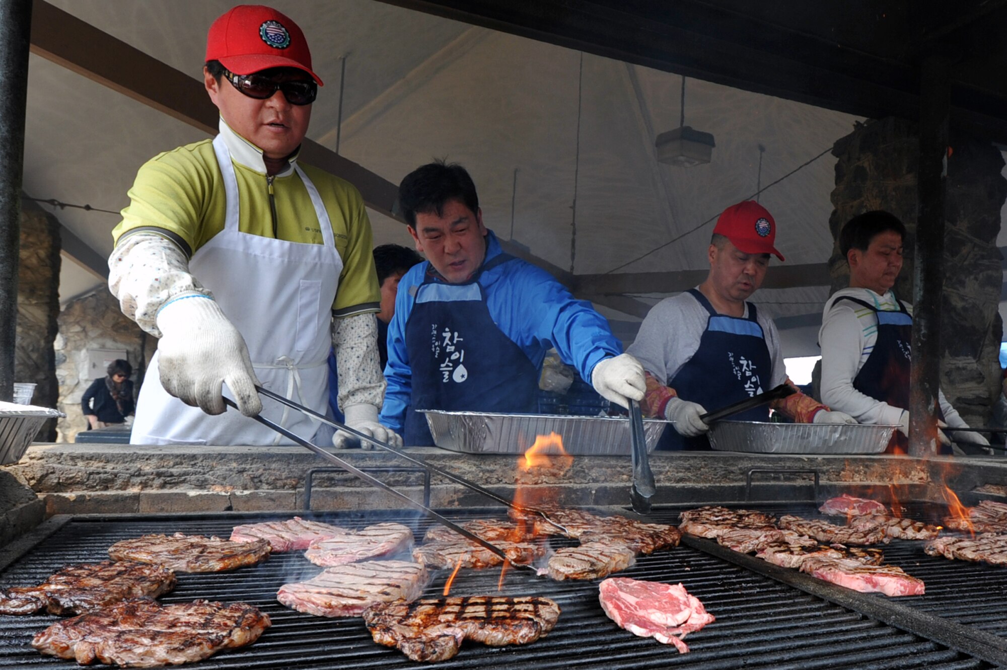 Grill masters prepare steak for the 2013 Korean Union Labor Day cookout at Osan Air Base, Republic of Korea, May 3, 2013. Hundreds of steaks were served to the Korean Union employees in celebration of all their hard work on base. (U.S. Air Force photo/Senior Airman Alexis Siekert)