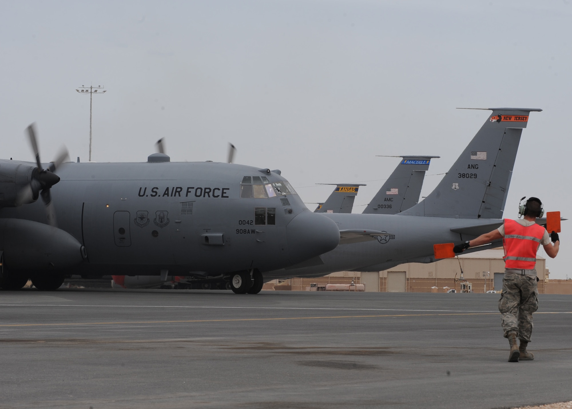 SOUTHWEST ASIA - Senior Airman Kendall Williams, 746th Expeditionary Aircraft Maintenance Unit, marshalls a C-130 out of its stub before its flight, May 1. In addition to maintenace, crew chiefs are required to help launch the aircraft out of the ramp. (U.S. Air Force photo/Staff Sgt. Joel Mease)