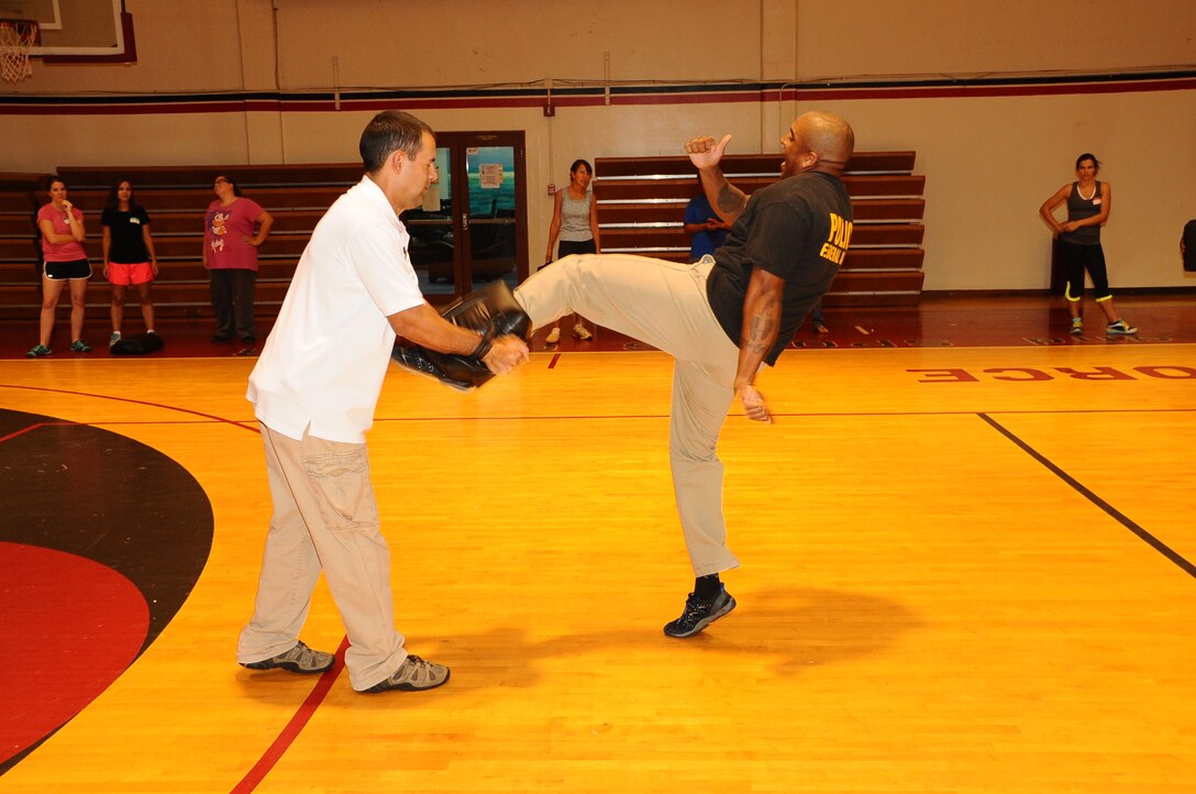 Special Agent Marquis Navarro, Air Force Office of Special Investigations, Detachment 602, kicks a combat sports bag during a self-defense class on Andersen Air Force, Guam, April 30, 2013. This was one of several events held in the month of April as part of Sexual Assault Awareness Month. (U.S. Air Force photo by Airman 1st Class Adarius Petty/Released)