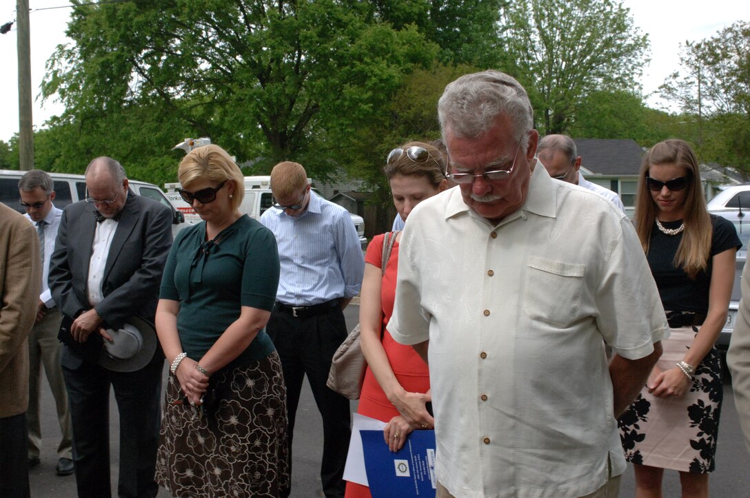 People participate in a moment of silence at the beginning of a ceremony to unveil a high water mark sign May 2, 2013 at England Park in Nashville, Tenn. Officials posted the sign to draw attention to flood risk and make them aware of how high waters rose during the May 2010 flood.