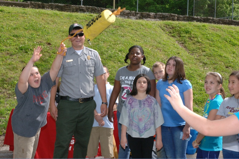 Park Ranger Dean Austin, U.S. Army Corps of Engineers Nashville District, teaches a young student from West Cheatham Elementary School how to throw a "Rescue" bag so a swimmer in distress can grab the rope and be pulled to safety. The students learned about water safety during Environmental Awareness Day May 2, 2013 at Cheatham Lake in Ashland City, Tenn.