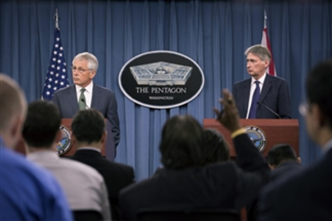 Secretary of Defense Chuck Hagel, left, and the United Kingdom's Secretary of State for Defence Phillip Hammond listen to a reporter’s question during a joint press conference in the Pentagon on May 2, 2013.  Hagel and Hammond told reporters about their earlier meeting where they discussed the situations in Syria, Iran and Afghanistan and then took questions.  