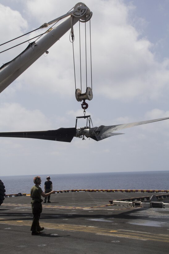 A U.S. Marine with Medium Tiltrotor Squadron 266 (Reinforced), 26th Marine Expeditionary Unit (MEU) guides a crane driver carrying a rotor of an MV-22 Osprey on the flight deck of the USS Kearsarge (LHD 3), at sea, May 4, 2013. The 26th MEU is deployed to the 5th Fleet area of operations aboard the Kearsarge Amphibious Ready Group. The 26th MEU operates continuously across the globe, providing the president and unified combatant commanders with a forward-deployed, sea-based quick reaction force. The MEU is a Marine Air-Ground Task Force capable of conducting amphibious operations, crisis response and limited contingency operations. (U.S. Marine Corps photograph by Gunnery Sgt. Michael Kropiewnicki/26th MEU Combat Camera/Released)
