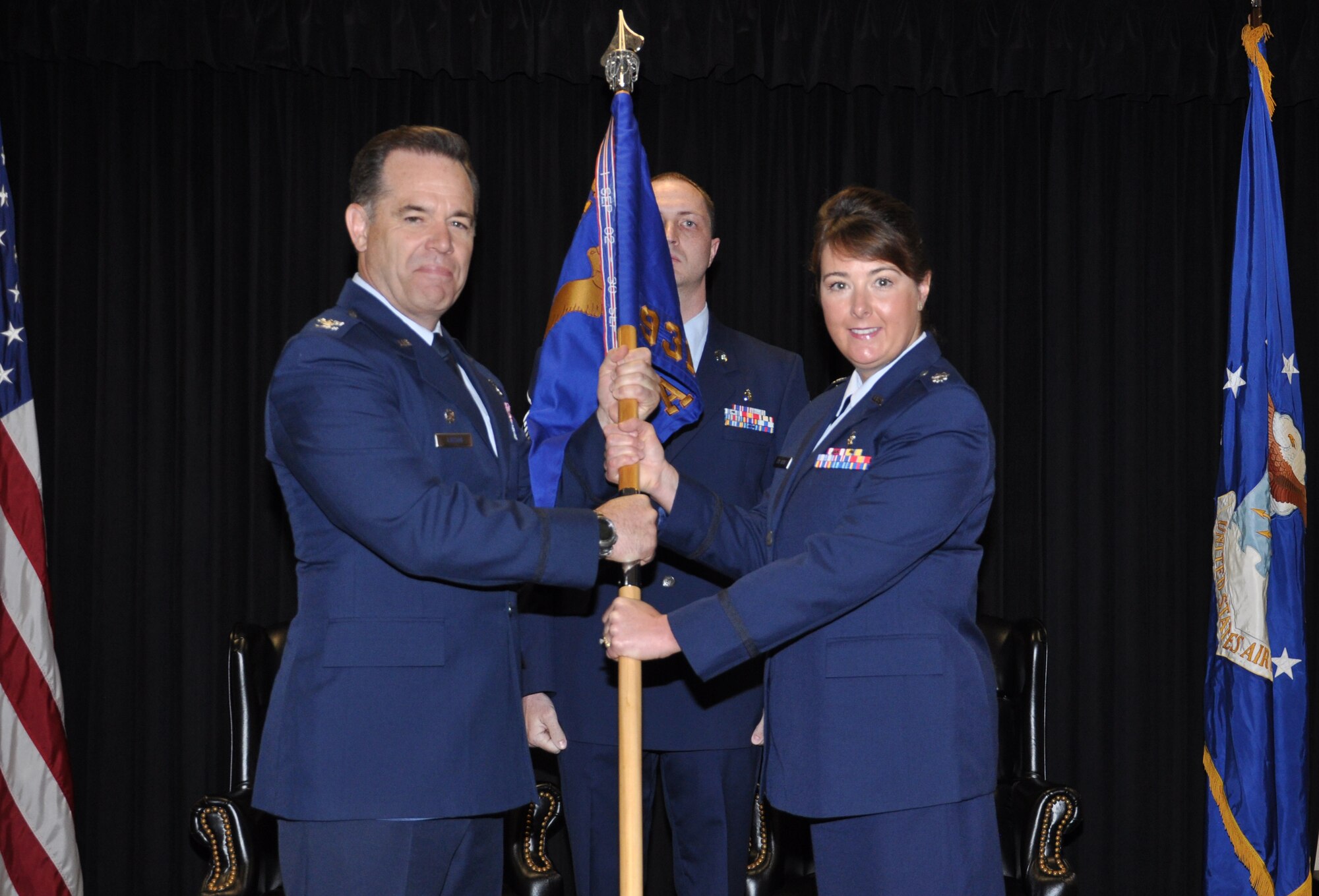 Col. Mark S. Larson, commander, 931st Air Refueling Group, passes the 931st Aerospace Medicine Squadron guidon to incoming squadron commander, Lt. Col. Michelle E. Van Sickle during an assumption of command ceremony, May 4. (Air Force photo by Master Sgt. Brannen Parrish)