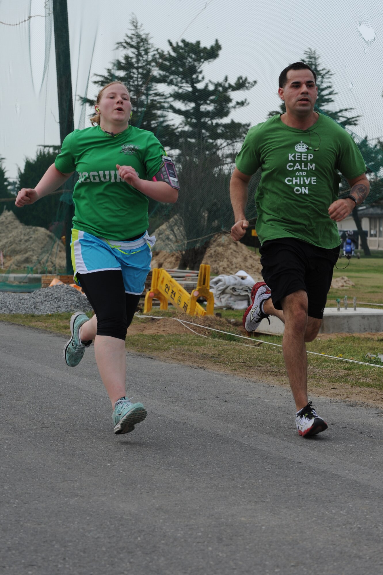 KUNSAN AIR BASE, Republic of Korea -- Senior Airman Laine Edwards and Staff Sgt. Gabriel Fraire, 8th Security Forces Squadron members, finish the April Fools Fun Run at Kunsan Air Base, Republic of Korea, April 27, 2013. Edwards was the first female runner to complete the 5 kilometer run with a time of 29:30. (U.S. Air Force photo by Staff Sgt. Jonathan Fowler/Released)