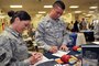 U.S. Air Force Staff Sgt. Emily Young and Senior Airman Adrian Hamilton, both with the 151st Air Refueling Wing, fill out questionnaires for the USAA representative at a resource fair for members of the Utah Air National Guard Base in Salt Lake City Utah, May 4, 2013. (U.S. Air National Guard photo by TSgt. Jeremy Giacoletto-Stegall)(RELEASED)