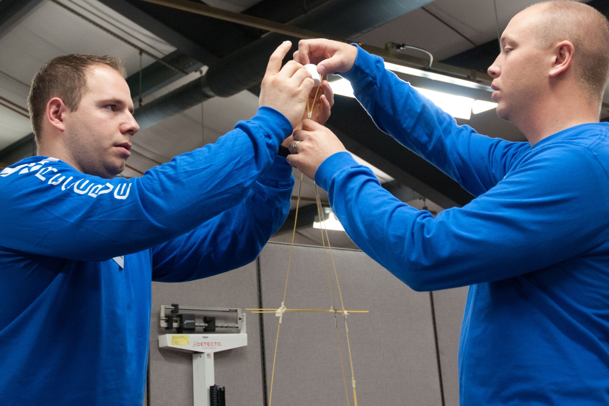 Trainees Chris Gustafson and Joshua Colonna work together to create the tallest free standing structure.  Members of the 934th Airlift Wing Development Training Flight competed in a marshmallow challenge on May 5, at the Minneapolis-St. Paul Air Reserve Station, Minn.  The challenge was to build the tallest free standing structure strong enough to hold a marshmallow and tested trainees on problem solving, making assumptions, and teamwork.  (US Air Force Photo/Staff Sgt. Samantha Wagner)