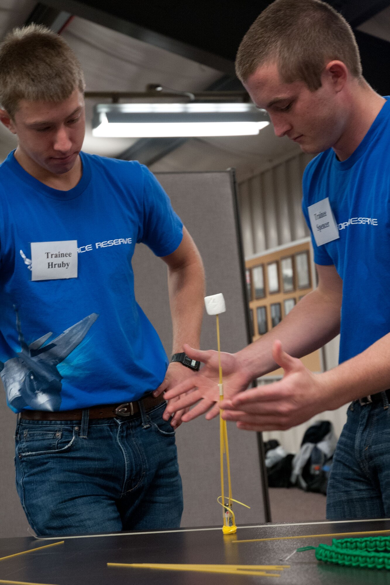 Trainees Justin Hruby and Derek Spencer test the strength of their structure.  Members of the 934th Airlift Wing Development Training Flight competed in a marshmallow challenge on May 5, at the Minneapolis-St. Paul Air Reserve Station, Minn.  The challenge was to build the tallest free standing structure strong enough to hold a marshmallow and tested trainees on problem solving, making assumptions, and teamwork.  Hruby and Spencer took second place with their free standing structure.  (US Air Force Photo/Staff Sgt. Samantha Wagner)