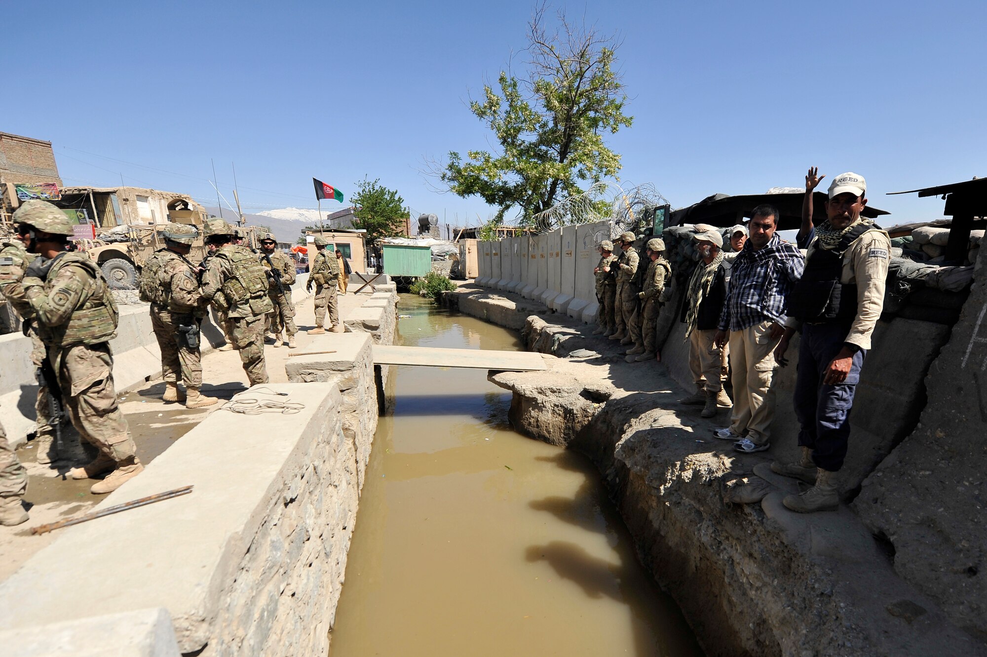Members of the 455th Expeditionary Civil Engineer Squadron replace the bridges at the entry control point to Bagram Airfield, Afghanistan, May 2, 2013. The 455th ECES structures shop was given a project to construct two bridges to replace the old and rotting matting and wooden planks that went over a flowing river that divided the airfield and the town outside the gates.  (U.S. Air Force photo/Senior Airman Chris Willis)
