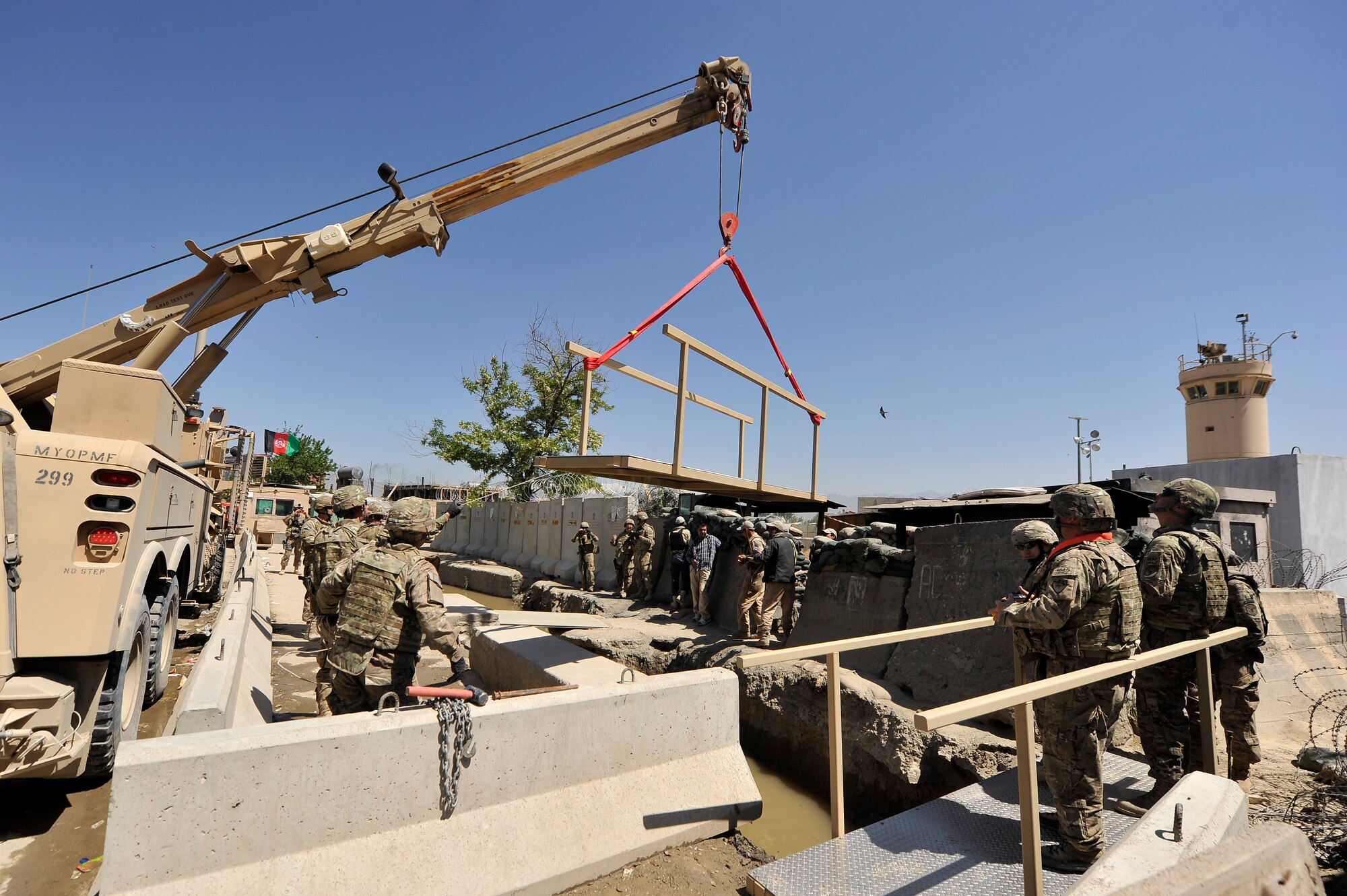 Airmen and local Afghan employees prepare to install new bridges to Bagram Airfield, Afghanistan, May 2, 2013.  The bridges were requested by the 455th Expeditionary Security Forces Squadron entry point controllers to provide safe passage to and from BAF for the airfield employees. (U.S. Air Force photo/Senior Airman Chris Willis)