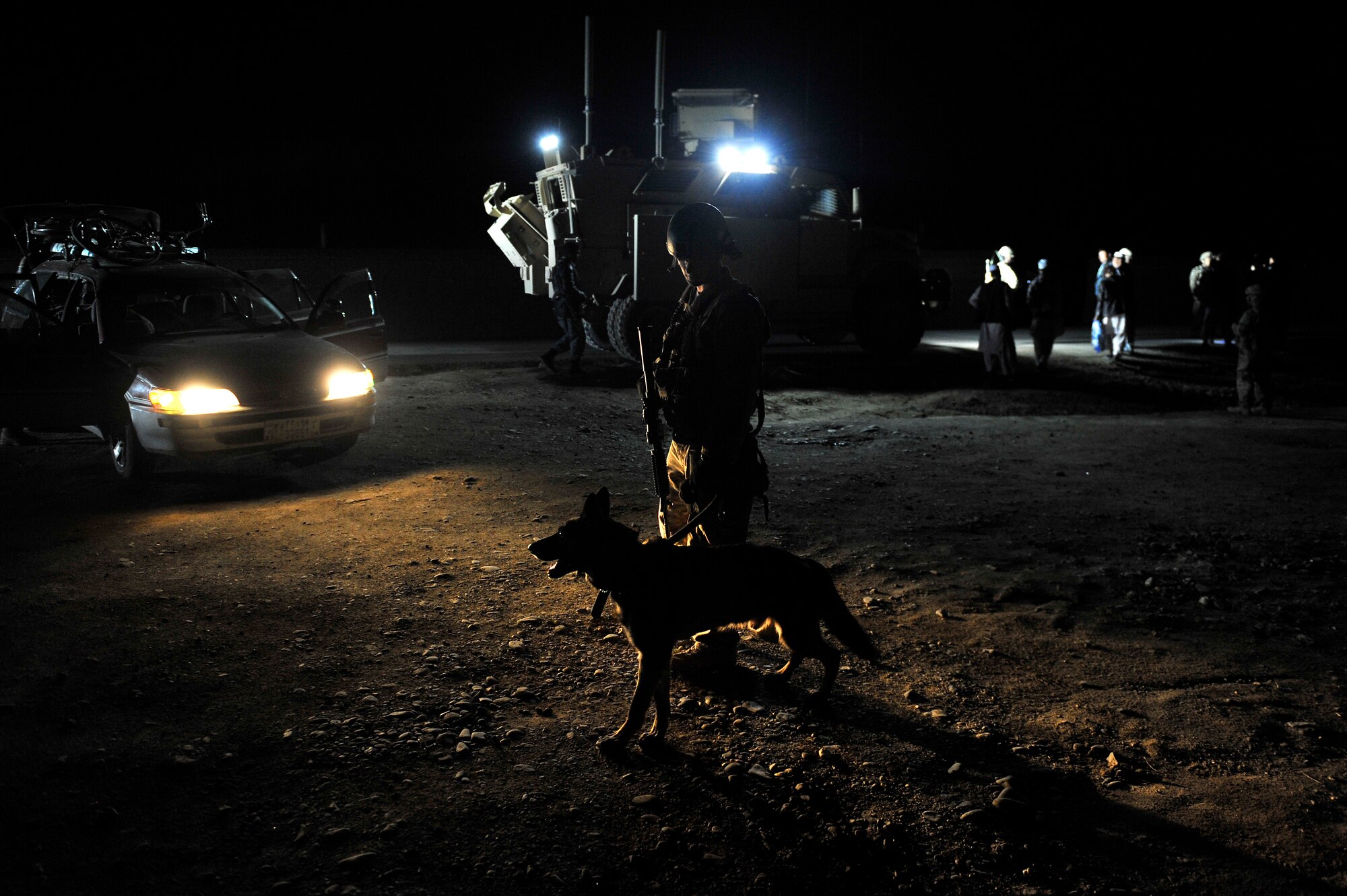Staff Sgt. Steven Owen, 455th Expeditionary Security Forces Group Military Working Dog handler, and his dog Tex conduct a night operations search at Traffic Control Points outside of Bagram Airfield, Afghanistan, April 28, 2013. TCPs provide an unpredictable security posture in which random vehicles are selected to be swept for contraband and all occupants identified and checked.  (U.S. Air Force photo/Senior Airman Chris Willis)