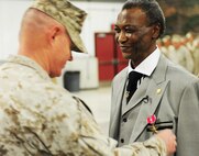 Col. Charles Sides, commanding officer of the 24th Marine Regiment, presents former Pfc. Robert L. Rimpson the Bronze Star Medal with Combat "V" device May 4, during an awards ceremony at the 24th Marine Regiment Drill Hall.