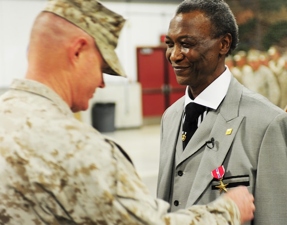 Col. Charles Sides, commanding officer of the 24th Marine Regiment, presents former Pfc. Robert L. Rimpson the Bronze Star Medal with Combat "V" device May 4, during an awards ceremony at the 24th Marine Regiment Drill Hall.