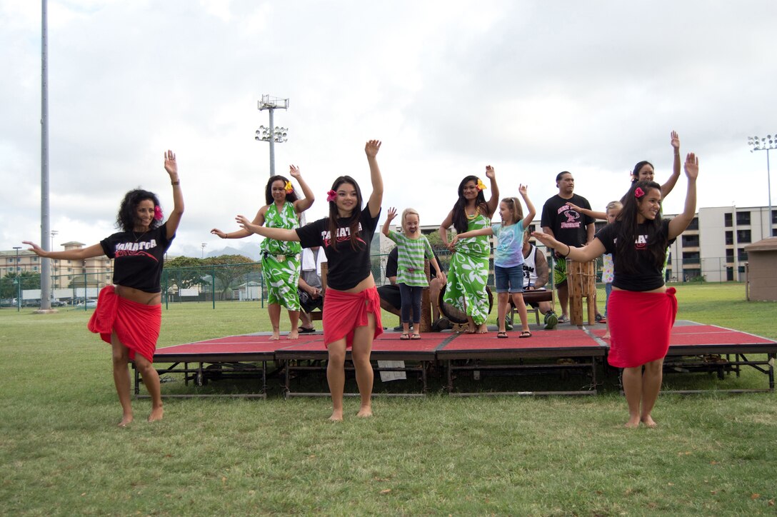 (From left to right) Dania Hill, Vaitiare Lejeune, and Lehiwia Stephenson, dancers for the Tamatoa halau, lead the performance for children willing to learn on the stage during "Hawaiian Culture In the Park" at Riseley Field, April 30, 2013. (U.S. Marine Corps photo by Rochelle Smolinski)