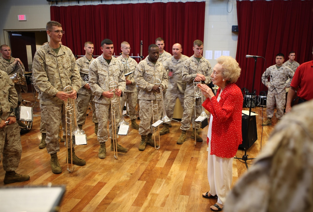 World War II veteran, Amelie Prados Cressend gives thanks to the Marine Corps Band New Orleans after they had performed the rearranged, updated and expanded arrangement of her original song, “Keep America Free,” at Marine Corps Support Facility band hall, May 6. Retired Marine Corps musician, Former Staff Sgt. Jake Johnson, and Marine Corps Band New Orleans worked together  to bring Cressend’s dream and musical vision to life by harmonizing and rearranging her original score, and adapting the song into their official repertoire. 
