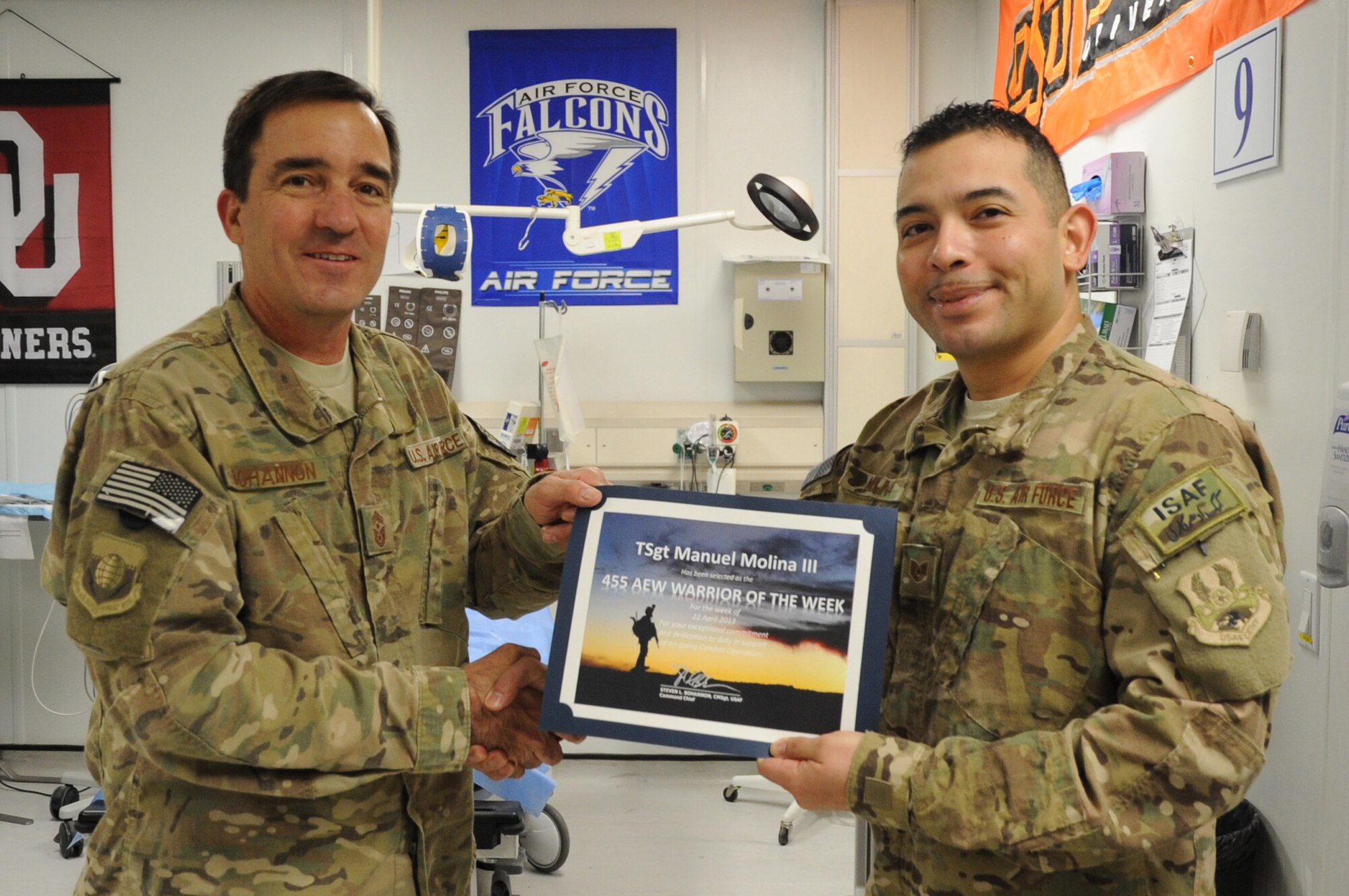 Chief Master Sgt. Steve Bohannon, Command Chief Master Sergeant of the 455th Air Expeditionary Wing, presents the "Warrior of the Week" award to Tech. Sgt. Manuel Molina III, 455th Expeditionary Medical Operations Squadron aerospace medical technician, on Bagram Airfield, Afghanistan, May 1, 2013. Molina orchestrated the annual EMT Rodeo at the Craig Joint Theater Hospital, where 13 teams practiced and honed their medical skills. (U.S. Air Force photo/Staff Sgt. David Dobrydney)