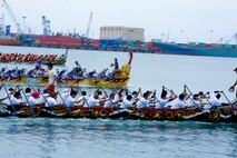 The Onaka Construction Company (black boat), Kadena Shogun Men (yellow boat) and Okinawa City Fire Department (green boat) members race during the Naha Dragon Boat Race in Naha City Port, Japan, May 5, 2013. This was the 39th annual dragon boat race, an Okinawan tradition, with both a women and men teams made up of active duty, civilians and family member volunteers. The dragon boat race is also a part of Golden Week, which is a collection of four different holidays Okinawans celebrate within seven days. (U.S. Air Force photo by Airman 1st Class Justin Veazie/Released)