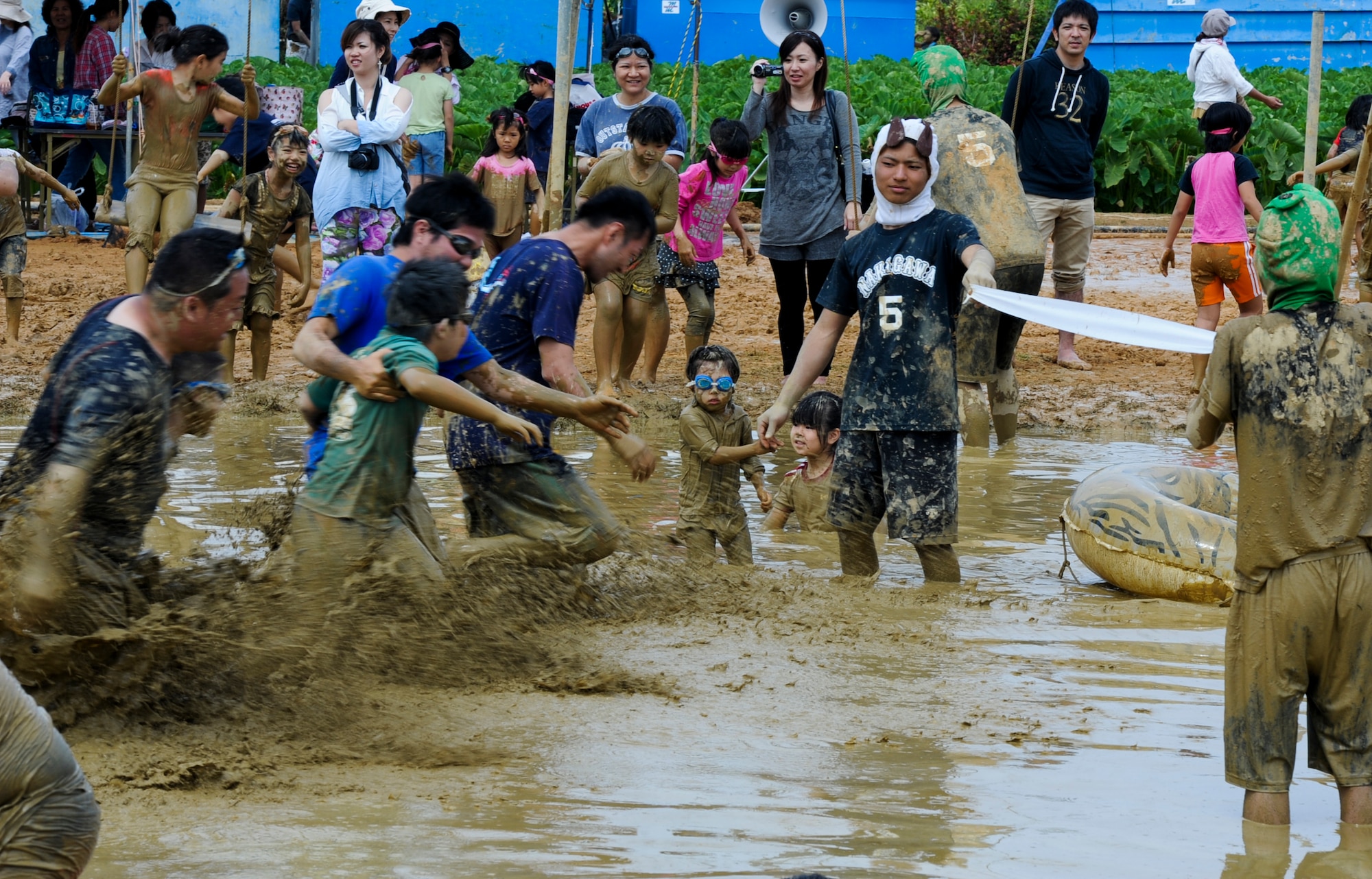 Japanese locals strive to win a three-legged race at the Rice Paddy Festival during Golden Week in Okinawa, Japan, May 3, 2013. The race was during the annual Kin Town Tanbo Festival, an event tailored towards kids playing in the mud. The Kin Town Tanbo Festival is part of Golden Week, which is a collection of four different holidays within seven days for the community. (U.S. Air Force photo by Airman 1st Class Justin Veazie/Released)
