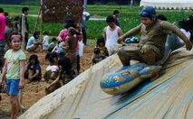 A local Japanese child slides down a ramp at the Rice Paddy Festival during Golden Week in Okinawa, Japan, May 3, 2013. During the annual Kin Town Tanbo Festival, an event tailored towards kids, children from across the island wear swim suits while they play in mud on the rice paddy playground. The Kin Town Tanbo Festival is part of Golden Week, which is a collection of four different holidays within seven days for the Okinawans. (U.S. Air Force photo by Airman 1st Class Justin Veazie/Released)