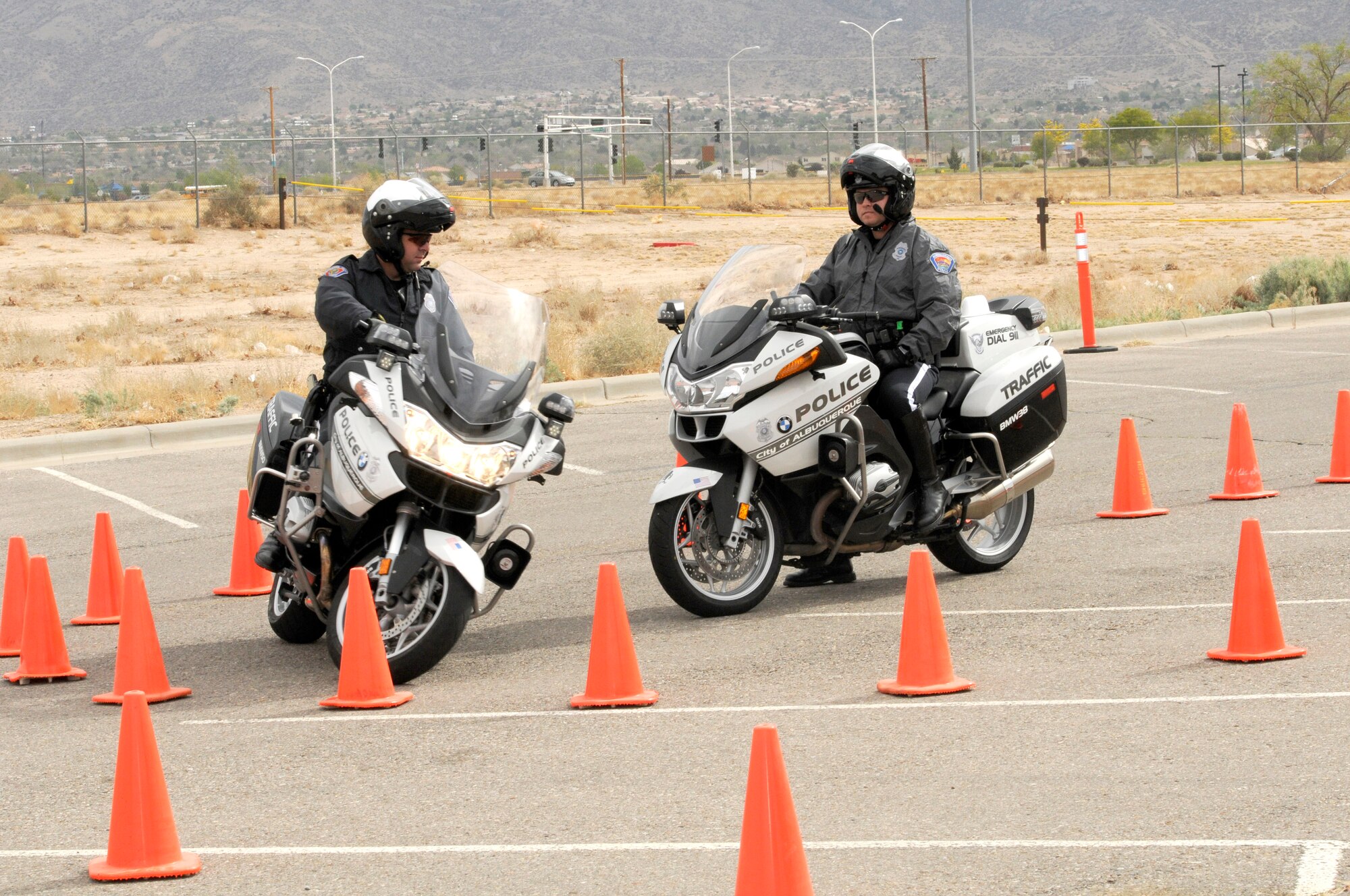 Officer Aaron Maldonado, Albuquerque Police Department, waits in the middle while his partner, David Weidner, demonstrates the cornering capabilities of his motorcycle at slow speeds during the Air Force Safety Center annual preseason motorcycle safety briefing held April 25 at the safety center. (U.S. Air Force photo by Keith A. Wright)