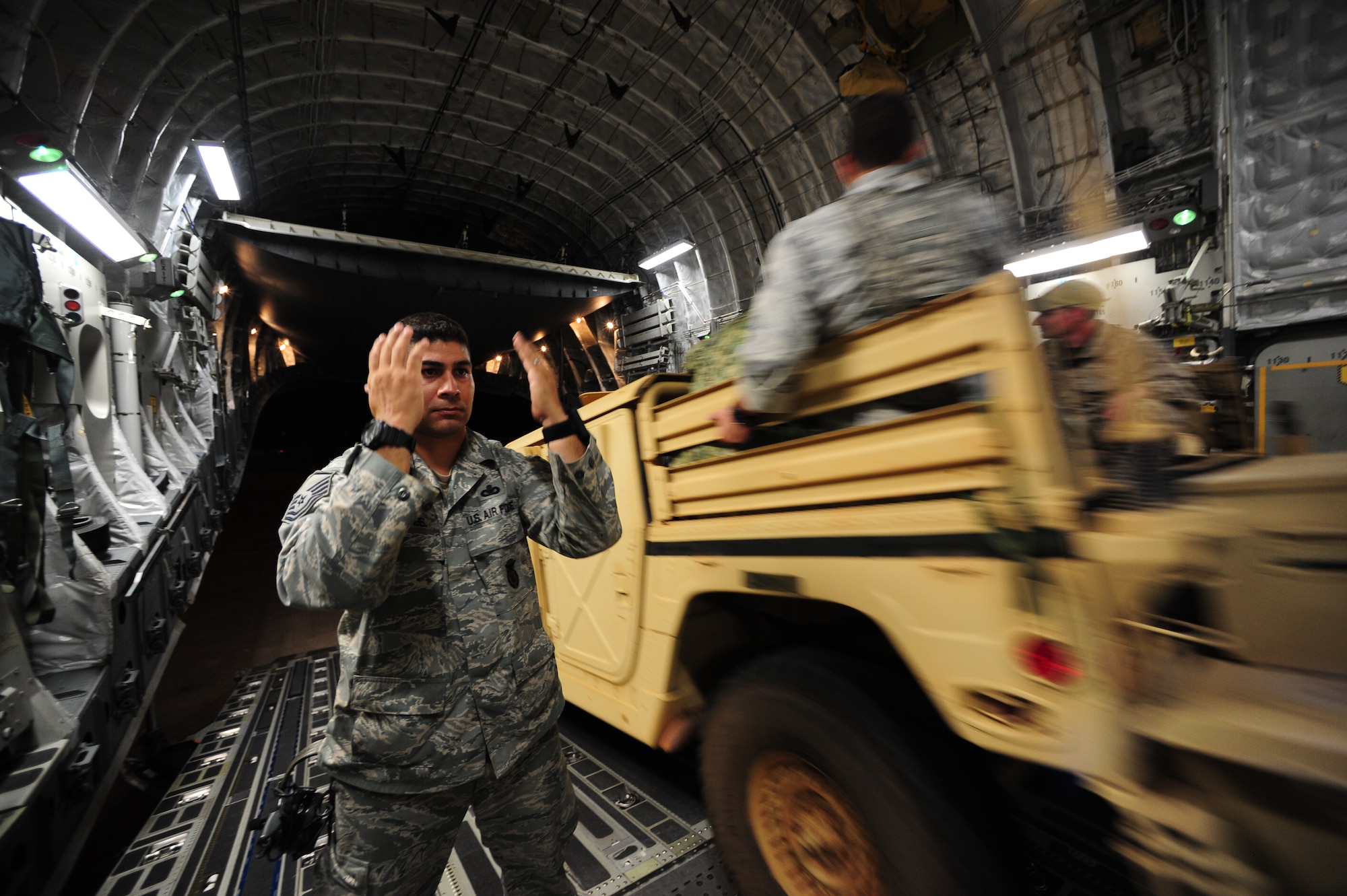 U.S. Air Force Master Sgt. Jason Rangel from the 1st Special Operations Security Forces Squadron, Hulbert Field, Fla., ushers vehicles off of a C-17 Gloabmaster III aircraft for  insert and extraction training during Emerald Warrior 2013 at Hurlburt Field, Fla., April 23. The primary purpose of Emerald Warrior is to exercise special operations components in urban and irregular warfare settings to support combatant commanders. Emerald Warrior leverages lessons from past conflicts to provide better trained and ready forces to combatant commanders. (U.S. Air Force photo by Tech. Sgt. DeNoris A. Mickle)(Released)