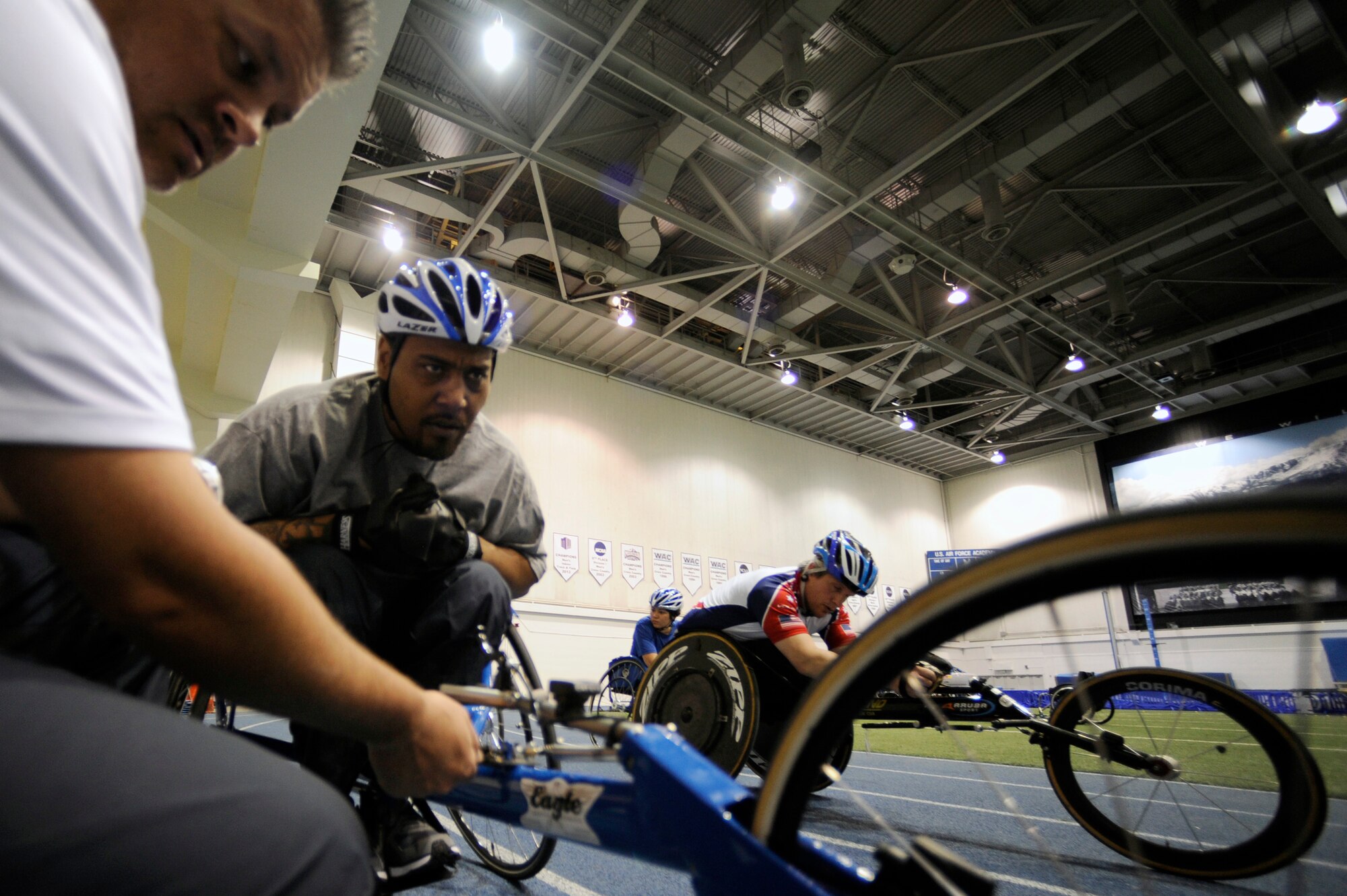 Former Senior Airman Darrell Fisher gets his racing chair adjusted by his coach before cycle practice at the U.S. Air Force Academy indoor track during the Air Force's Warrior Games training camp  April 17, 2013, in Colorado Springs, Colo. Fisher was incurred a gunshot wound that left him paralyzed. Fisher resides in Colombia, S.C. (U.S. Air Force photo/Desiree Palacios)