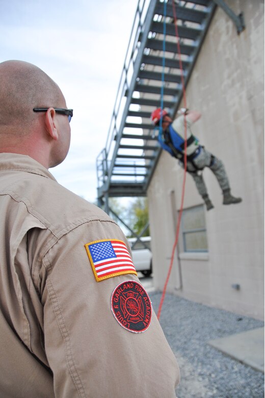 YOUNGSTOWN AIR RESERVE STATION, Ohio -- Tech. Sgt. Devon Parsons, 910th Civil Engineer Squadron firefighter, performs ground safety as Staff Sgt. Owen Brownfield, 910th CES firefighter, practices rapelling during annual fire training May 5, 2013, here. (U.S. Air Force photo/Staff Sgt. Megan Tomkins)