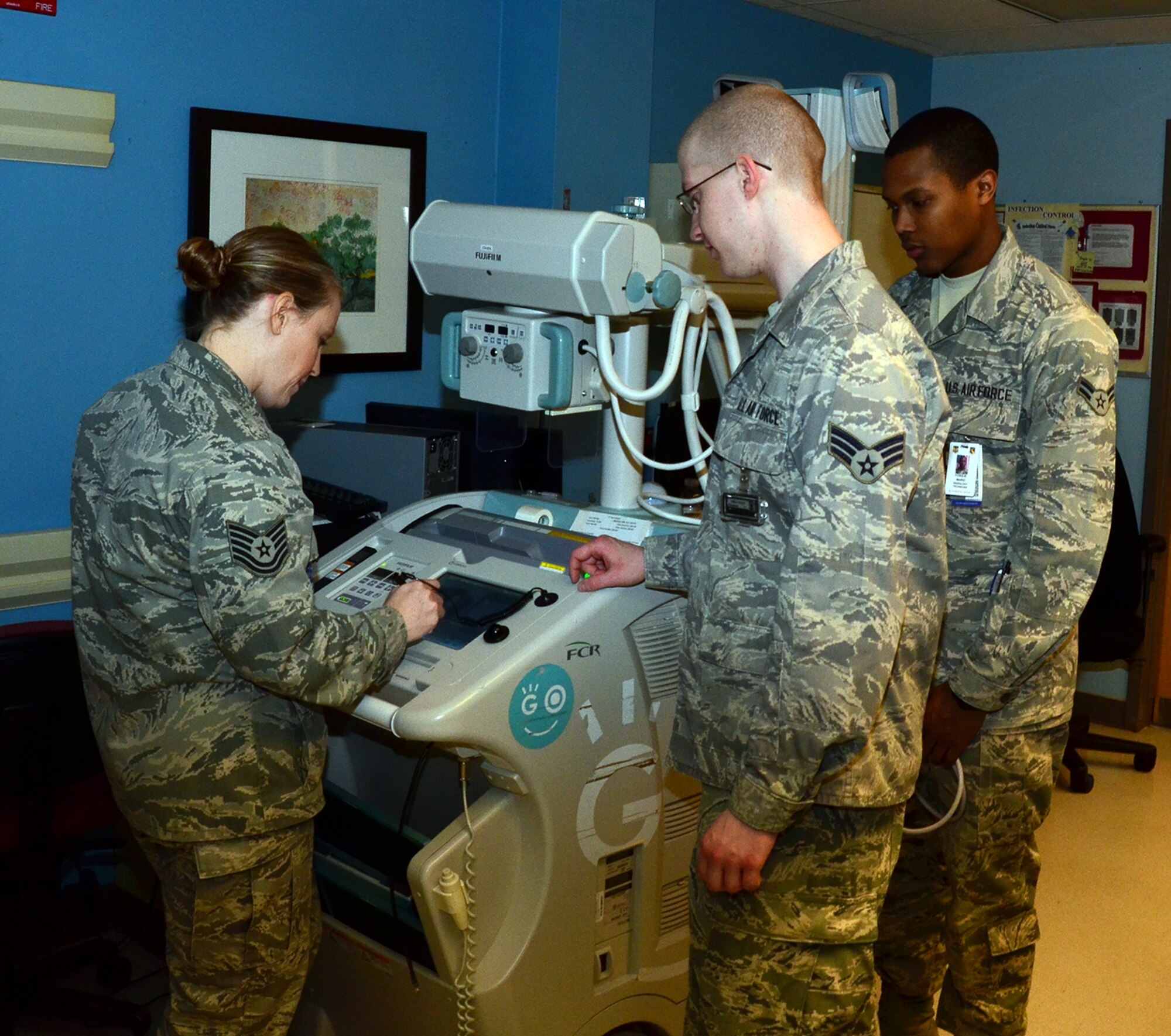 WRIGHT-PATTERSON AIR FORCE BASE, Ohio - Tech.  Sgt. Ashby Jakober, 445th Aeromedical Staging Squadron radiology technician and on the job training monitor, reviews an X-ray as Senior Airman Andrew Holby and Airman 1st Class Mario Fosque, both 88th Medical Group radiology technicians observe during training April 15 at the Wright-Patterson Medical Center. Twenty-two ASTS Airmen conducted their annual tour April 6 – 20 at the WPAFB Medical Center where they received training in job classification skills, sustainment and readiness skills in various departments to include the laboratory, pharmacy, nursing, medical administration, surgical technology and radiology. (U.S. Air Force photo/Lt. Col. Cynthia Harris)