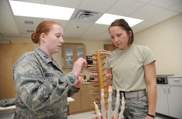 Capt. Laura Dossett, 81st Surgical Operations Squadron occupational therapist, demonstrates a functional activity for hand rehabilitation to Capt. Jessica San Felippo, 81st MSGS, May 3, 2013, at the Keesler Medical Center, Keesler Air Force Base, Miss.  Dossett is Keesler’s only occupational therapist and works primarily with arm, wrist and hand ailments that restrict every-day tasks.  (U.S. Air Force photo by Kemberly Groue)