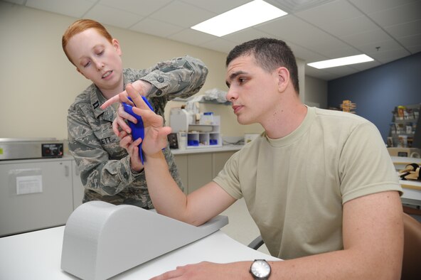 Capt. Laura Dossett, 81st Surgical Operations Squadron occupational therapist, demonstrates how to apply a fabricated splint on Airman 1st Class James Morgan, 81st MSGS, May 3, 2013, at the Keesler Medical Center, Keesler Air Force Base, Miss.  Dossett is Keesler’s only occupational therapist and works primarily with arm, wrist and hand ailments that restrict every-day tasks.  (U.S. Air Force photo by Kemberly Groue)
